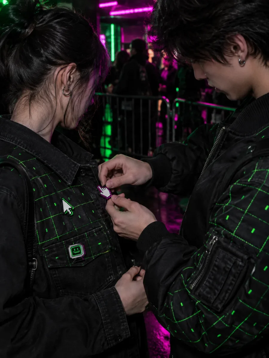 Two friends swapping pins between their grid jackets
